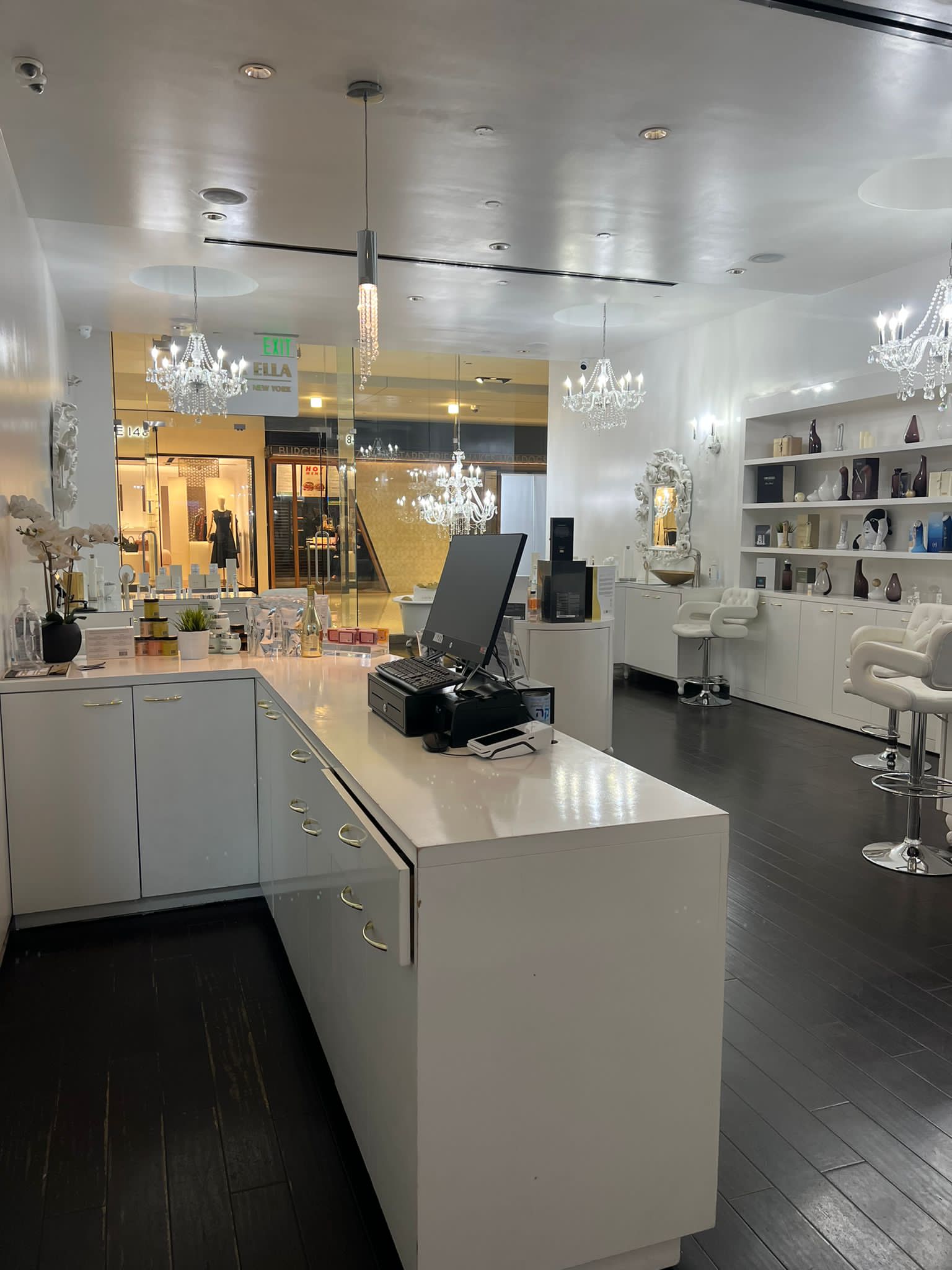 The actual Donna Ella Spa reception, with white walls, gold accents and pink flowers